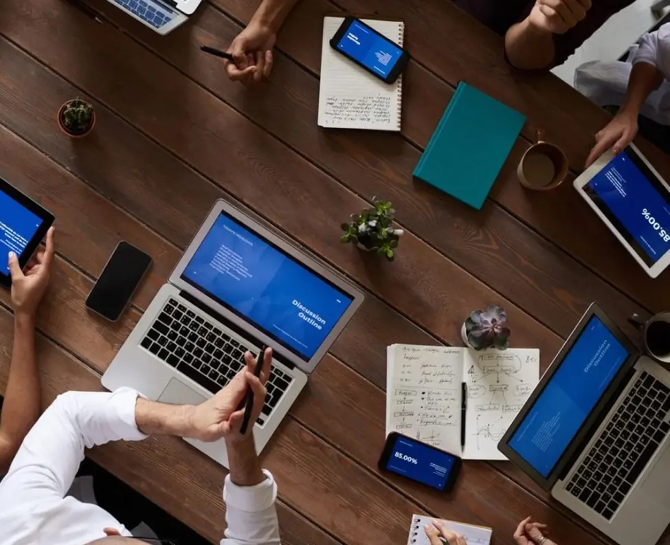 Notebooks and screens on the same table.